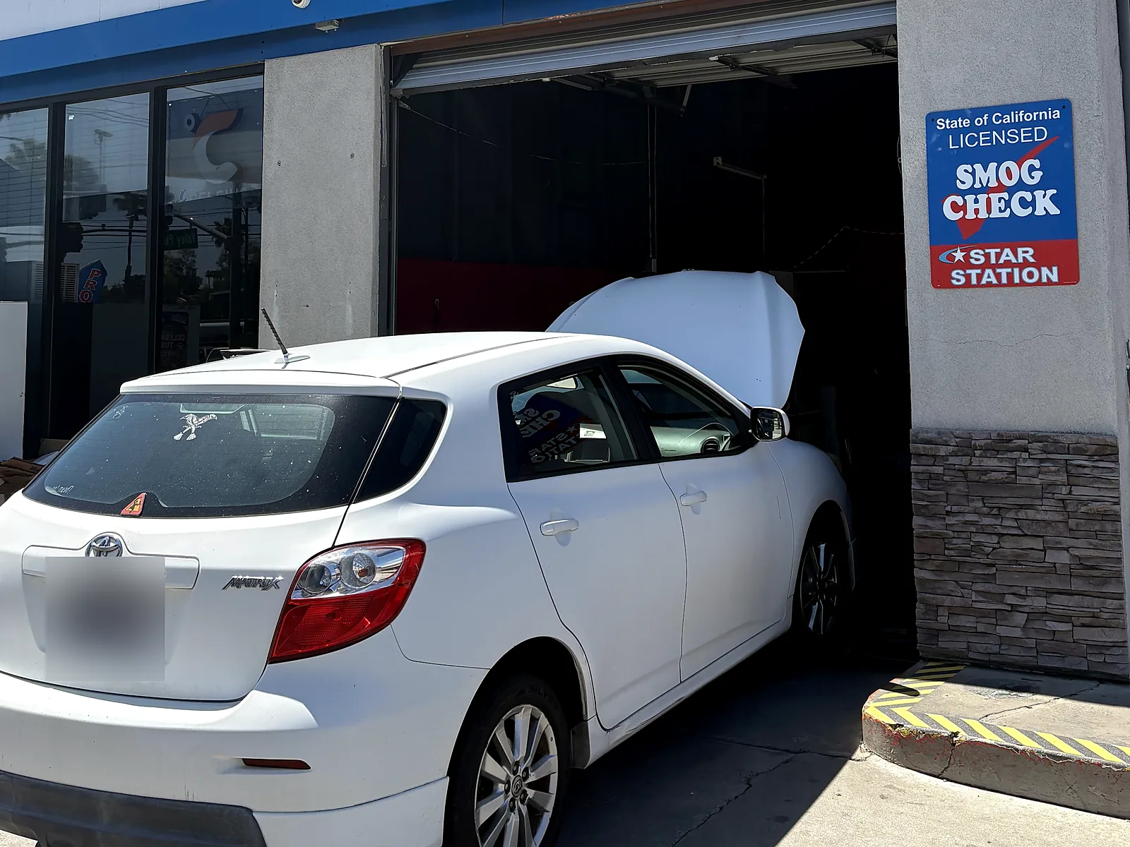Out-of-state vehicle smog check in Escondido, CA: Toyota Matrix with the hood up in our bay